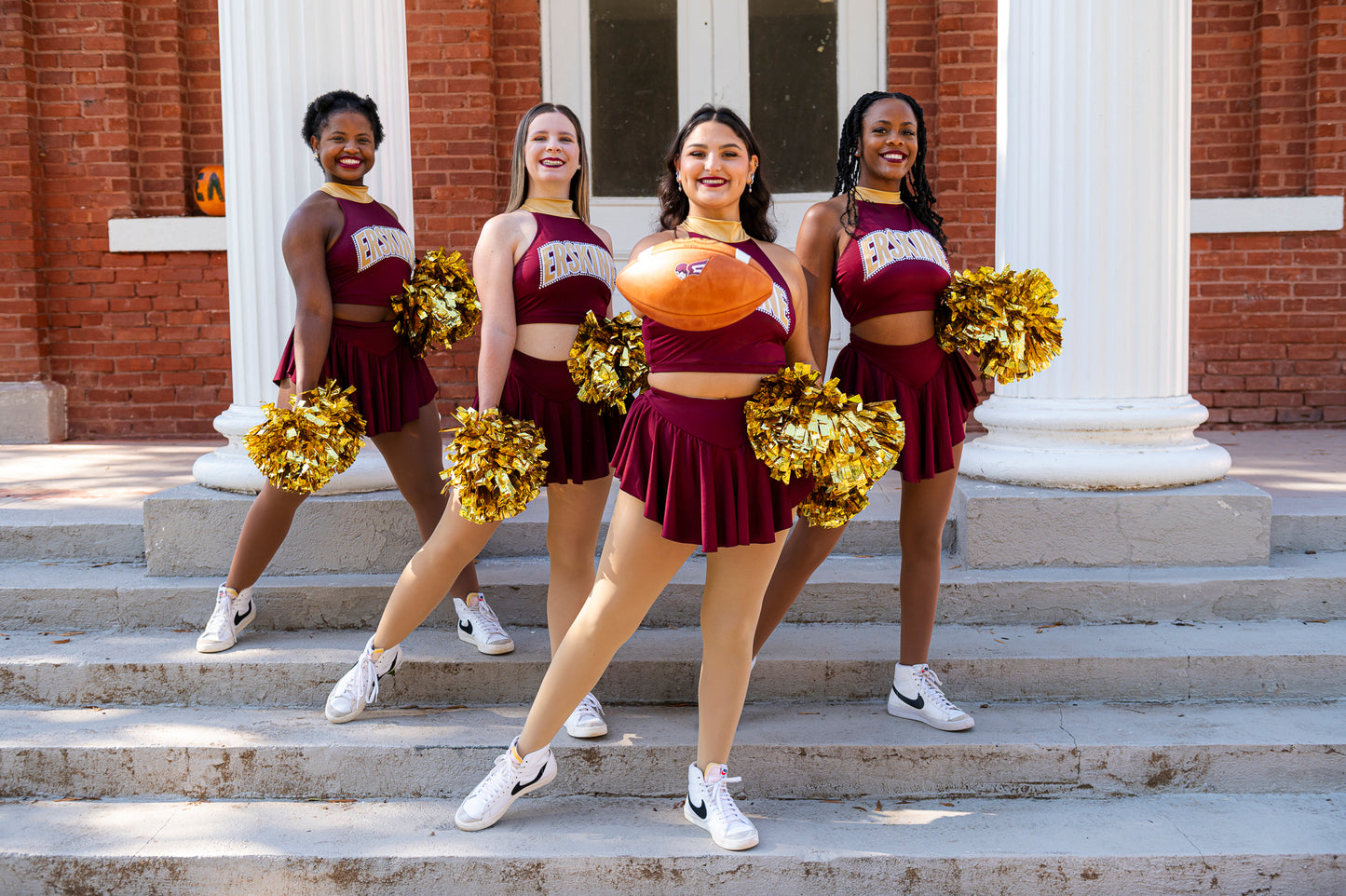 Cheer team members pose on the steps of Euphie