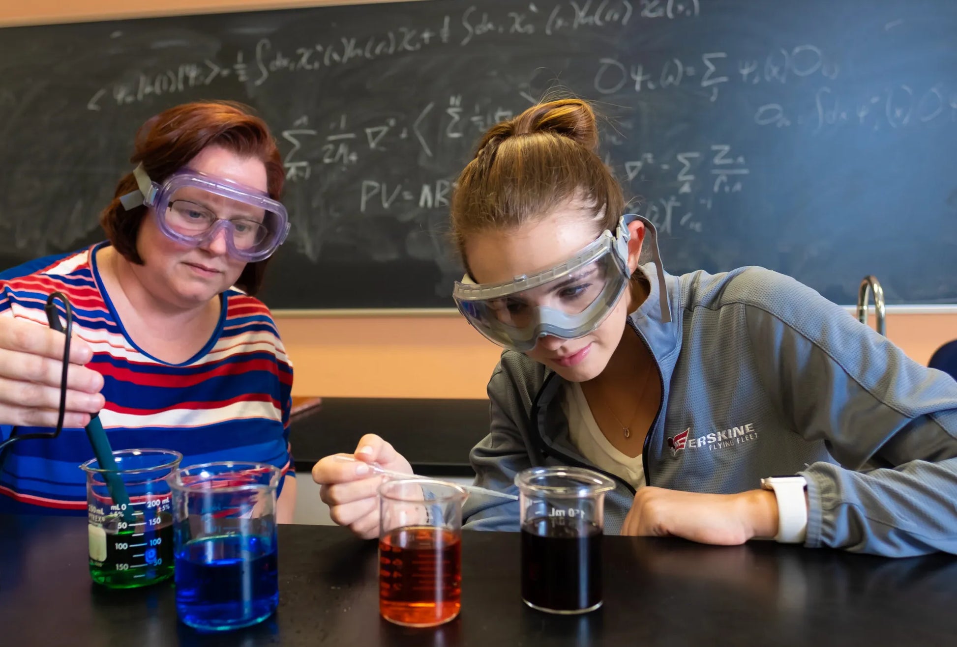 A professor and student work together on a chemistry experiment