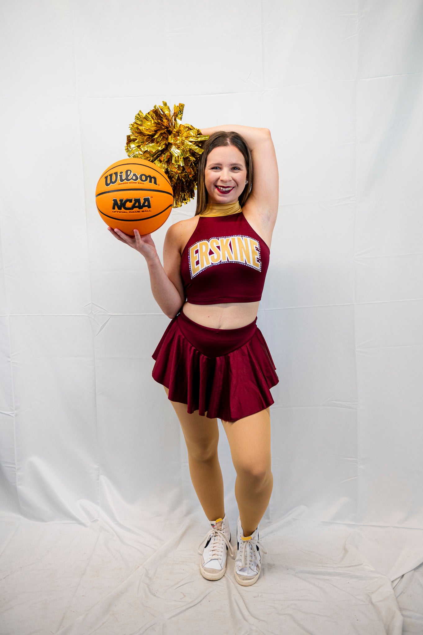 A member of the cheer team holds a basketball
