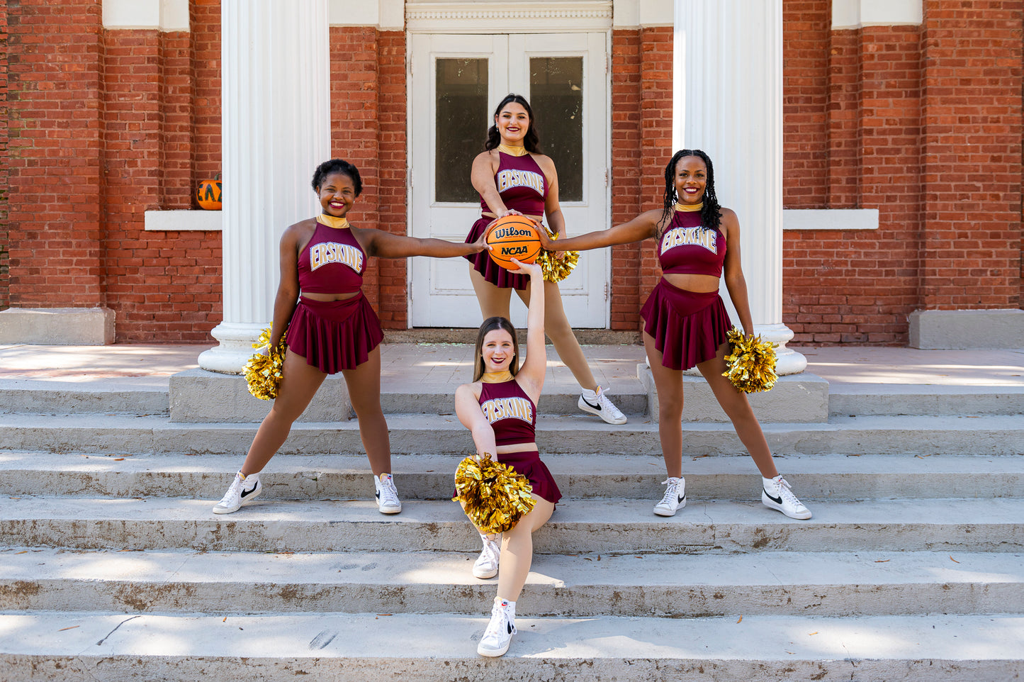 Cheerleaders pose with a basketball