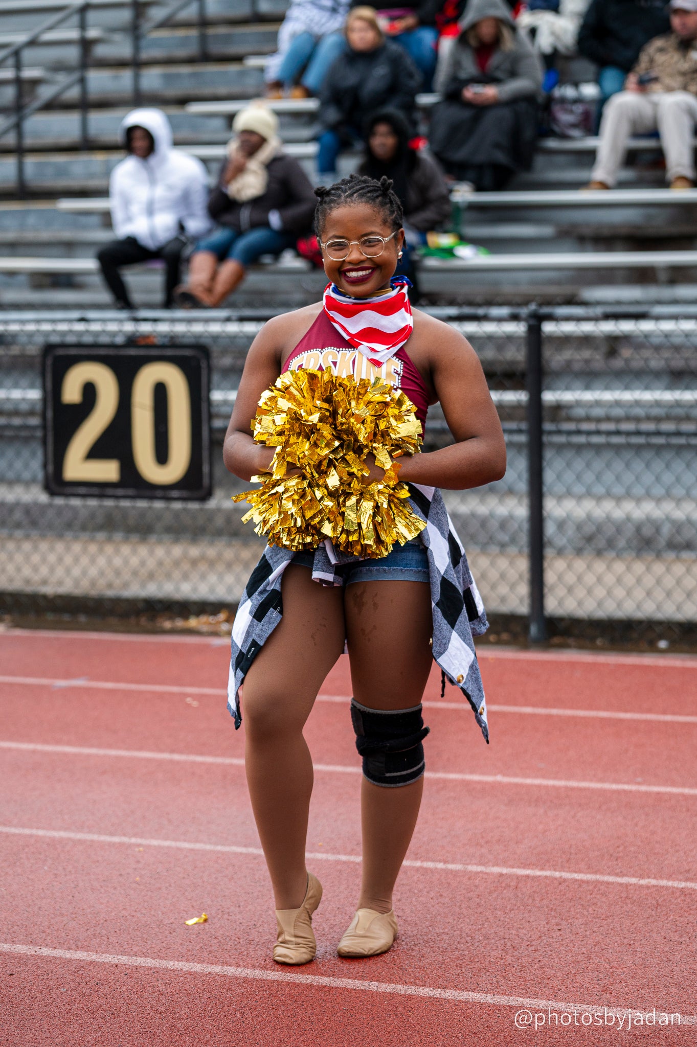 Cheerleader poses in front of the stands at a Fleet football game